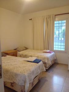 a bedroom with two beds and a window at Casa en Lomas del Rey - Mayu Sumaj in San Antonio de Arredondo +8 photos