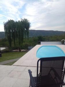 a chair next to a swimming pool on a patio at Casa en Lomas del Rey - Mayu Sumaj in San Antonio de Arredondo