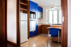 ベルガモにあるマイルーム ゲスト ハウスのキッチン(青いキャビネット、白い冷蔵庫付)