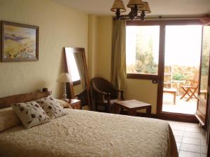 a bedroom with a bed and a sliding glass door at Hotel Triskel in Jávea