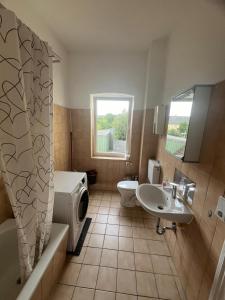 a bathroom with a tub toilet and a sink at Zentral gelegene Erdgeschoss-Wohnungen mit bequemer Erreichbarkeit in Neumünster