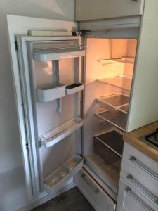 an empty refrigerator with its door open in a kitchen at Sari in Steendam