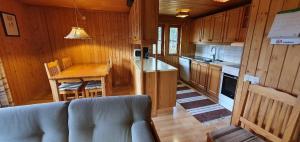 a kitchen with a couch and a table in a room at Sauna | Wi-Fi | Terrace | Wood stove | Cable TV in Lofsdalen