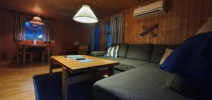 a living room with a couch and a table at Sauna | Wi-Fi | Terrace | Wood stove | Cable TV in Lofsdalen