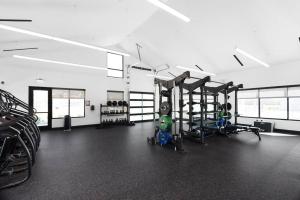 a gym with several tread machines and a child in the middle at Perfect Spot Cozy Stay Coffee Shop Bar Onsite in Pflugerville