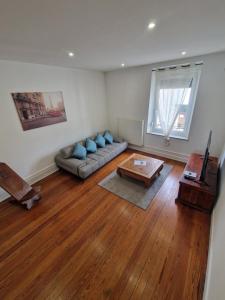 a living room with a couch and a table at bel appartement,confortable,2chambres in Briey