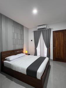 a bedroom with a large bed and a window at Rauda Living Space Syariah in Pasuruan +42 photos