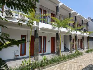 a row of buildings with palm trees in front at Rauda Living Space Syariah in Pasuruan