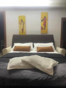 a bedroom with a bed with two paintings on the wall at Casa Vacanza Betty in Partanna
