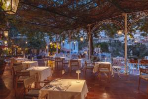 a restaurant with white tables and chairs and lights at Hotel Poseidon in Positano