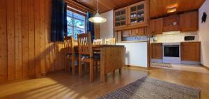 a kitchen with wooden cabinets and a table and chairs at Sauna | Wi-Fi | Terrace | Wood stove | Cable TV in Lofsdalen