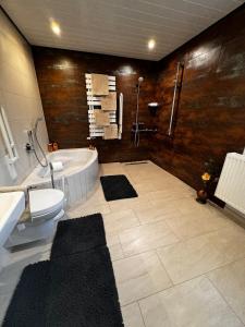 a bathroom with a tub and a toilet and a sink at Auszeit am Riedbach in Lindenberg im Allgäu +22 photos