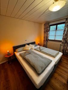 a large bed in a bedroom with a window at Auszeit am Riedbach in Lindenberg im Allgäu
