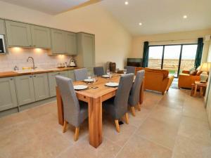 a kitchen and dining room with a wooden table and chairs at Little Rissington - Barn Four in Little Rissington