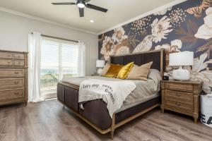 a bedroom with a bed and a wall with flowers at Pour House in Dauphin Island +29 photos