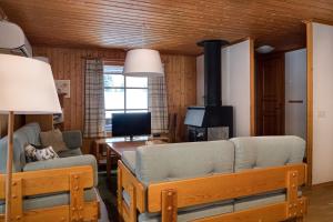 a living room with a couch and a stove at Sauna | Wi-Fi | Terrace | Wood stove | Cable TV in Lofsdalen