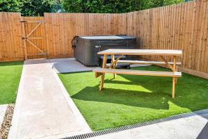 a picnic table and a bench next to a fence at Little Rissington - Barn Six in Little Rissington