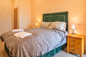 a bedroom with a large bed and a night stand at Little Rissington - Barn Six in Little Rissington