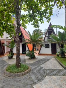 a house with a tree in the middle of a courtyard at Chalés Monções in Ubatuba