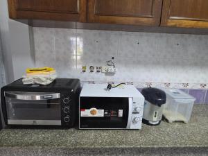 un forno a microonde e un tostapane su un bancone della cucina di Diamond Home in Phuket a Ban Rangeng