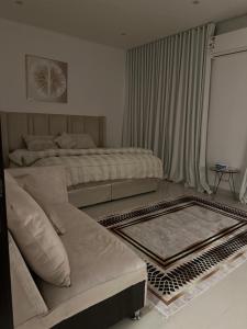 利雅德شقة نوريلا的有两张床和一张沙发的客厅