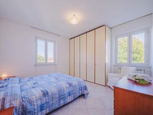 een slaapkamer met een bed, een dressoir en 2 ramen bij Holiday Home Lucerna Due-5 by Interhome in Ameglia