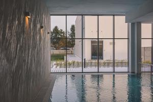 a swimming pool in front of a building with windows at Let's Sea by 2HomeRent in Gąski