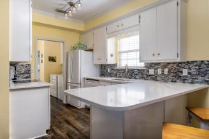 Una cocina con gabinetes blancos y una encimera blanca. en Crew Rest, en Dauphin Island 69 fotos más