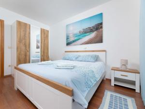 a bedroom with a large white bed and a table at Apartment Mirta by Interhome in Šilo
