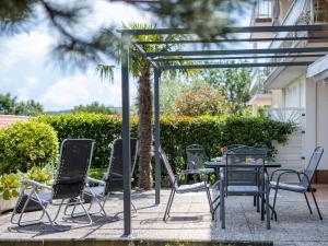 a group of chairs and a table with a umbrella at Apartment Mirta by Interhome in Šilo