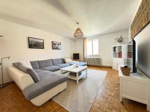 a living room with a couch and a tv at "Le Cœur de la Vieille Ville" in Porrentruy