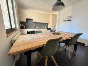 a kitchen with a wooden table and two chairs at "Le Cœur de la Vieille Ville" in Porrentruy