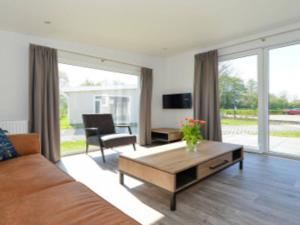 un soggiorno con un divano e un tavolo di Holiday Home Hart van Zeeland by Interhome a heinkenszand Altre 12 foto