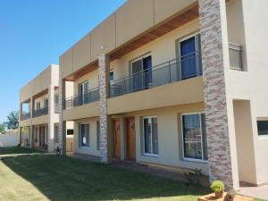 Un edificio de apartamentos con césped delante. en Complejo Marlu, en Federación