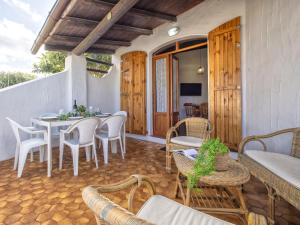 a patio with a table and chairs and a television at Holiday Home Doria by Interhome in La Ciaccia