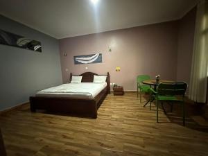 ein Schlafzimmer mit einem Bett und einem Tisch und Stühlen in der Unterkunft REBERO RESORT Ltd in Kigali
