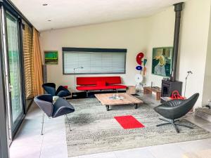 a living room with a red couch and chairs at Holiday Home Villa Vrijheid by Interhome in Hollum