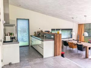 a kitchen with a table and a dining room at Holiday Home Villa Vrijheid by Interhome in Hollum