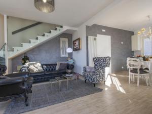 a living room with a black couch and a staircase at Holiday Home Il Paradiso by Interhome in Massa e Cozzile
