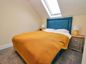 a bedroom with a large bed with a yellow blanket at Little Rissington - The Studio Apartment in Little Rissington