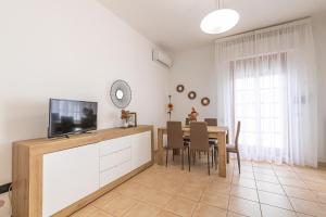 a dining room with a tv and a table with chairs at Casa Vacanza Gaia in Magliano