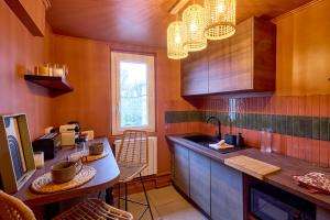 a kitchen with wooden cabinets and a table with chairs at Studio Bali en hyper centre de Nevers in Nevers
