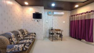 a living room with a couch and a table at LD Guest House, Ayodhya in Ayodhya