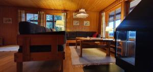 a living room with a couch and a table at Sauna | Wi-Fi | Terrace | Wood stove | Cable TV in Lofsdalen
