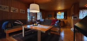 a living room with a couch and a table at Sauna | Wi-Fi | Terrace | Wood stove | Cable TV in Lofsdalen