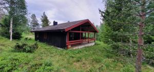 a small house on a hill in a field at Sauna | Wi-Fi | Terrace | Wood stove | Cable TV in Lofsdalen