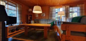 a living room with a couch and a table at Sauna | Wi-Fi | Terrace | Wood stove | Cable TV in Lofsdalen +5 photos
