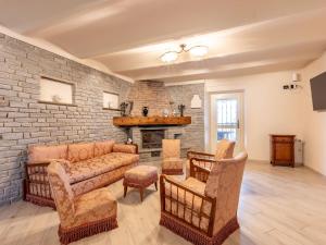 a living room with a couch and chairs and a fireplace at Holiday Home Villa Creviolo by Interhome in Loazzolo