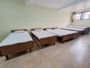 a row of four mattresses in a room at LD Guest House, Ayodhya in Ayodhya