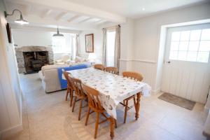 a dining room with a table and chairs and a living room at Otter Cottage in Pwllheli